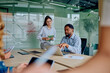 © we.bond.creations - Business professionals discussing work and sharing ideas in a modern glass office. Colleagues planning strategy using technology