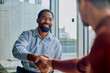© we.bond.creations - Diverse businessmen shaking hands and smiling during a meeting, celebrating a successful deal and new professional partnership