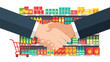 © Naim - Handshake over a shopping cart filled with various colorful products on a representing partnership and ecommerce