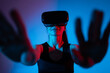 © Volodymyr_sh - Woman using VR headset with extended hands in neon lighting while engaging with virtual reality interface