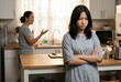 © Worldwide - A tense moment between two individuals in a kitchen setting.