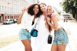 © halayalex - Three young beautiful smiling hipster female in trendy summer clothes.Sexy carefree multiracial women posing on the street background.Positive models having fun in sunglasses. Cheerful and happy