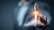 © Tanu - Business person launches a rocket with a finger, representing innovation and progress in a corporate environment