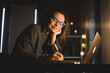 © olezzo - Mature happy woman working on laptop in home office at evening