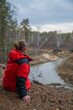 © Kseniya Ananko - a girl sits on a cliff above the river