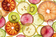 © Nadhif - Flat lay composition of translucent backlit fruit and vegetable slices including grapefruit, kiwi, and radish creating a colorful healthy texture.