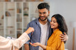 © Home-stock - Real estate agent giving keys to young indian buyers, happy woman taking key of future new apartment, spouses buying new house