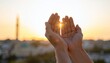 © Rizki zf - Cinematic close up of human hands raised in prayer (Dua) with mosque minaret silhouette at sunset. Muslim person supplicating to God in golden hour light.