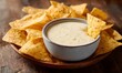 © simba kim - delicious looking chip dipping into white queso sauce,