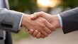 © Bussakon - Two businessmen shaking hands outdoors in soft sunlight symbolizing agreement and partnership