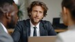 © Bussakon - Three professionals in business attire engaged in a focused discussion around a laptop in a modern office environment