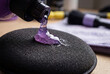 © Anastasiia Terenteva - Auto detailing supplies. Pouring purple polishing compound onto a black foam buffing pad. Preparation for car paint correction