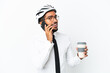© luismolinero - Young business latin man holding a bike helmet isolated on white background holding coffee to take away and a mobile