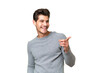 © luismolinero - Young handsome caucasian man over isolated background pointing finger to the side and presenting a product