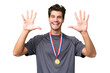 © luismolinero - Young caucasian man with medals over isolated background counting ten with fingers