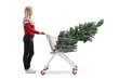© Ljupco Smokovski - Full length profile shot of a woman with a christmas tree in a shopping cart
