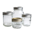 © Ameliaa - Four clear glass canning jars of varying sizes with metal lids on a black background