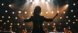 © petrrgoskov - Female orchestra conductor leading musicians on a concert stage under dramatic warm lights, creating an inspiring classical music performance atmosphere.