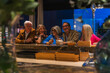 © pablo - Five mature friends are sitting at an evening bar counter, smiling and socializing together