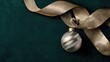 © mila103 - A decorative ornament hangs from a ribbon on a dark green surface. The ornament has silver stripes and the ribbon has a gold tone. This scene captures a festive moment related to holidays.