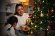 © geargodz - mother and toddler girl decorating Christmas tree in home at night