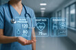 © praewpailyn - Nurse holding virtual medical technology display showing blood pressure heart rate and diagnostics in modern hospital corridor conveying clinical monitoring and advanced medical technology