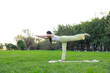 © leungchopan - Woman doing balance yoga pose at park