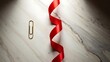 © MSTKolpana - Red ribbon and paper clip on marble surface