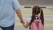 © TO LOVE - father’s care on a busy street, Child in ponytails heading to school, Safety at pedestrian crossing, Morning rush with family, Holding hands for security, Crossing road carefully, Pink backpack