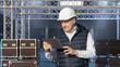 © Grispb - Event production management as a supervisor reviews setup plans on a tablet, coordinating staging structures and equipment for seamless technical operations.