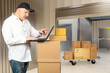 © Grispb - Parcel management as a worker uses a laptop atop stacked boxes to update shipment data, organizing packages and coordinating delivery tasks in a storage facility.