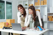 © Natee Meepian - Collaborative E-commerce Team in Office with Laptop and Packages