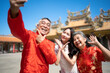© Velocitystock777 - Chinese family taking a selfie after praying at a Chinese temple.