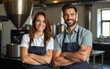 © shuai - Caucasian man with and woman standing with crossed arms. Looking directly at camera while smiling positively. Confidently posing together in bright coffee roasting facility. Teamwork. High quality