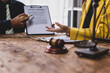 © Wasan - Lawyers discussing contract and agreement on wooden table.