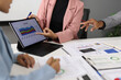 © Wasan - Business people discussing marketing strategy analyzing financial statistics data using digital tablet and documents during corporate meeting at office.