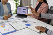 © Wasan - Business people discussing marketing strategy analyzing financial statistics data using digital tablet and documents during corporate meeting at office.