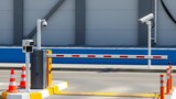 Automatic barrier gate system with security cameras and traffic cones at an entrance or exit point