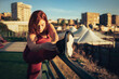 © Lomb - Curvy runner stretching leg on railing in urban park before evening workout