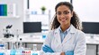 © Vasiliy - Portrait of a confident female scientist in a modern laboratory. Smiling young researcher in a lab coat with arms crossed. Science and medical research concept
