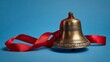 © thenort - A close-up shot of a golden bell with intricate carvings, a red ribbon wrapped around it against a blue backdrop