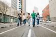 © Xavier Lorenzo - Group of diverse young friends running together on street. Joyful millennial students enjoying outdoor fun in the city. Youth energy and friendship concept.