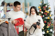 © JackF - Positive young male and female customers reviewing women's handbags in clothing shop during Xmas