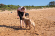 © GeeVee - woman playing with her dog at the beach