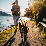 Młoda kobieta biegnie razem z psem border coli którego trzyma na smyczy