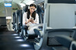 © Dejan - A woman wearing headphones relaxes in a train seat while using her smartphone, immersed in her digital world, illustrating modern travel experiences.