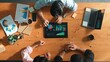 © InfiniteFlow - Top aerial view of business man present financial graph to group of smart investors. Professional male leader analyze graph and explain marketing idea by using tablet on meeting table. Convocation.
