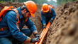 © Vadym - Construction workers install orange fiber optic internet cables underground in trench. Men in hard hats and safety vests lay conduit for new communication infrastructure in city development project.