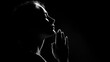 © Naufal - Silhouette of a woman praying with hands pressed together at sunset, expressing faith, hope, spirituality, and peaceful devotion in a serene atmosphere.
