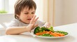 © Alena - Young Boy Making Face Refusing to Eat Vegetables at Table
